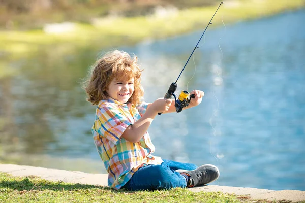Jungfischer. Kinderangeln. Kind mit Spinner am Fluss. Porträt eines aufgeregten Jungen, der mit der Angel auf dem See angelt. Fischereikonzept. — Stockfoto