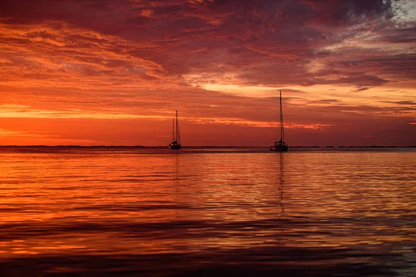 Yachting og reising. Båt til sjøs ved solnedgang. Seilbåter med seil. – stockfoto