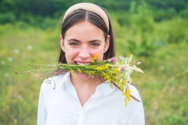 Vejetaryen konsepti. Organik alan. Yaban çiçekleriyle çayırda bahar kızı. Sağlıklı yaşam tarzı.