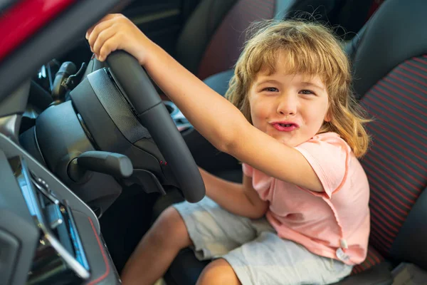 Παιδί οδηγός. Παιδί αγόρι οδηγεί αυτοκίνητο ως οδηγός. Μικρό παιδί κάθεται στη θέση του. — Φωτογραφία Αρχείου