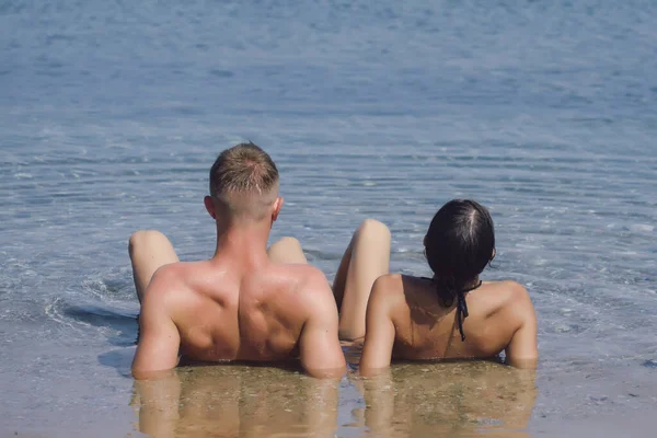 Verano pareja romántica en la playa relajarse en el agua de mar. — Foto de Stock