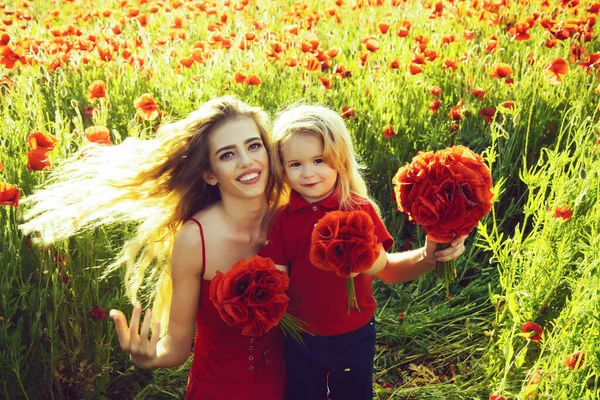 Spring girl and little boy or child in field of poppy. — Stock Photo, Image