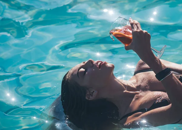 Sexy meisje holding cocktail op de zee of zwembad achtergrond. — Stockfoto