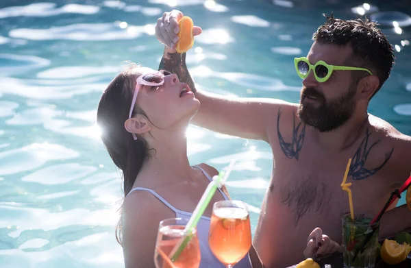 Zomervakantie en zwemmen op zee. Een paar met cocktail en fruit in Miami. Cocktail voor man en meisje op de Malediven. Zwembad partij ontspannen in spa resort. Vrienden en familie. — Stockfoto