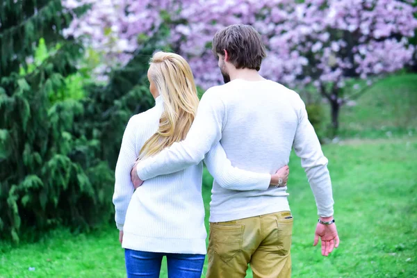 Couple, femme et homme s'embrassent dans un jardin fleuri, vue de dos. Couple sensuel rendez-vous au parc du printemps. Printemps, réveil de la nature, saison de la beauté. Amour, romance, relations, famille. — Photo