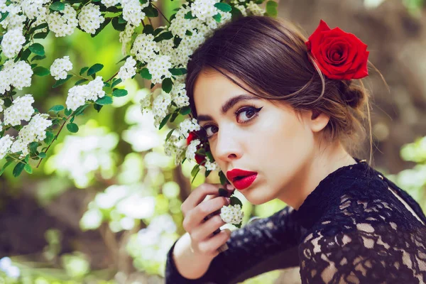 在夏天的花园子里,美丽的、性感的、年轻的西班牙女子在绽放鲜花.美丽的女孩，红唇，开着白花. — 图库照片