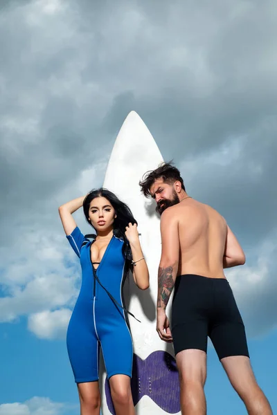 Een paar zomervakantie. Sexy vrouw in bikini. Summertime concept. Sexy man in badpak. Surfplank. — Stockfoto