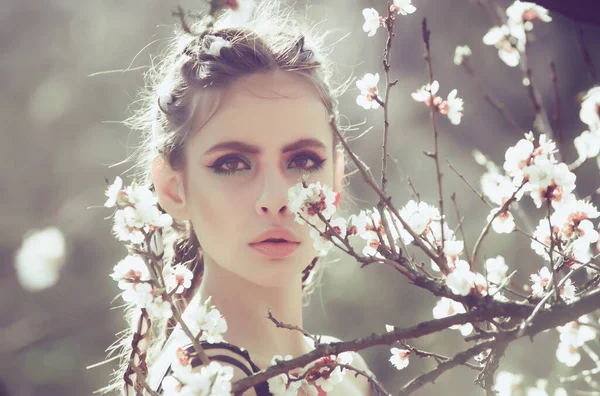 Ragazza primaverile in ciliegio bianco o albicocca fiore primaverile. bella donna con trucco alla moda sul viso e capelli alla moda all'aperto soleggiato. — Foto Stock