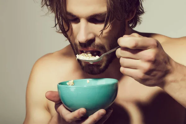 Κοντινό πορτραίτο του ανθρώπου με κουτάλι. Πρωινά δημητριακά, υγιεινά τρόφιμα για τον άνθρωπο ή αθλητή σε γκρι φόντο. — Φωτογραφία Αρχείου