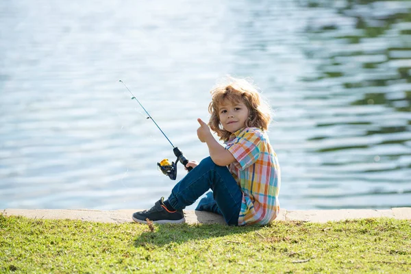Passatempi per bambini. Pesca bambino sul lago. Ragazzo con la trottola al fiume. Ragazzo al molo con asta. — Foto Stock