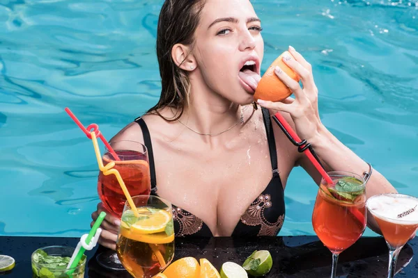 Zomer vrouw met verse alcohol in Miami. Drink vers vitamine sap, dieet. Zwembad partij ontspannen in spa resort. Zomervakantie en zwemmen op zee. Cocktail met fruit bij sexy meisje in zwembad. — Stockfoto