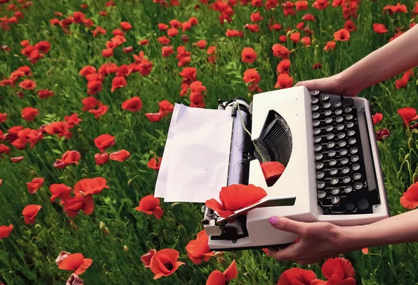 Dzień Anzaka. Wiosenne kwiaty i maszyna do pisania z pustym papierem na polu kwiatowym. Wspominanie. — Zdjęcie stockowe