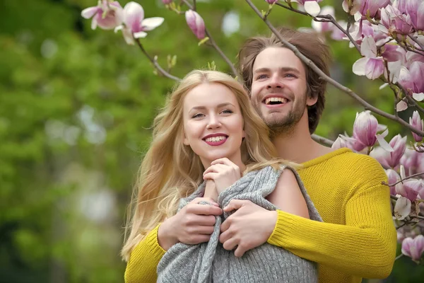 Froher Frühling. Verliebtes Paar im Frühling Magnolienblüten, lächelnder Mann und Mädchen im Garten mit Blütenbaum im Freien auf natürlichem Hintergrund. — Stockfoto