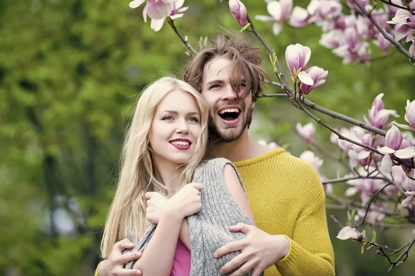 Verliebte Paare genießen die rosafarbene Magnolienblüte auf blühenden Bäumen. Frühlingspark an einem idyllischen, sonnigen Tag auf verschwommenem Blumenmilieu. Tagträume. — Stockfoto