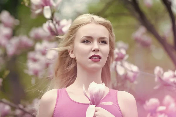 Lente, natuur en milieu. Magnolia bloem bloesem en vrouw in bloesem park. — Stockfoto