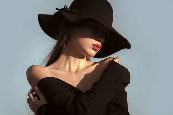 Elegante mujer con labios rojos hombros desnudos en sombrero negro. Retrato de belleza y moda. —  Fotos de Stock