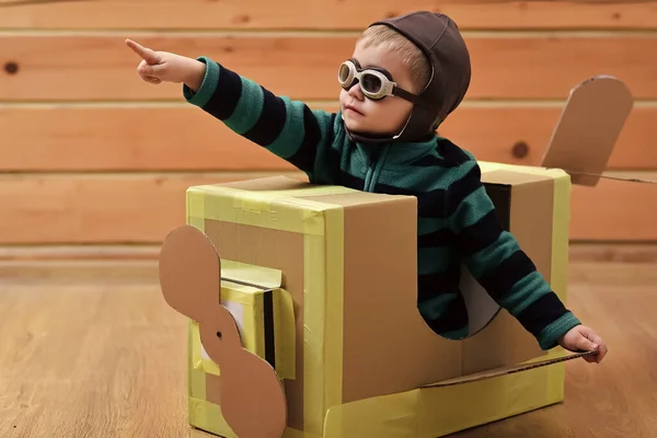 Criança bebé é piloto. Kids Travel, imaginação. Menino criança brincar em avião de papelão, infância. Entrega de correio aéreo, construção de aeronaves. Sonho aventura. — Fotografia de Stock