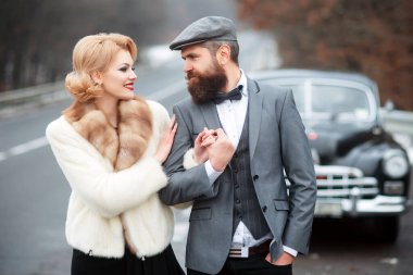 Dışarıda eski bir arabanın yanında yürüyen bir çift. Eski tarz. Birbirine aşık çiftler..