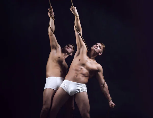 Gespierde sexy jongens met een naakt bovenlijf. Hunks met een atletisch lichaam. Twee blanke mannen tweeling in dezelfde houding. — Stockfoto