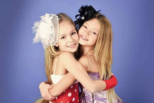 A divatruhás lányok ölelkeznek, boldog nővérek. Gyerekbarátság. Divat és szépség, kis hercegnő. — Stock Fotó