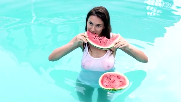 Frutas de verão. Mulher sexy comer melancia na piscina. Conceito de comida saudável, frutas da estação, festa de verão, lanches. — Vídeo de Stock