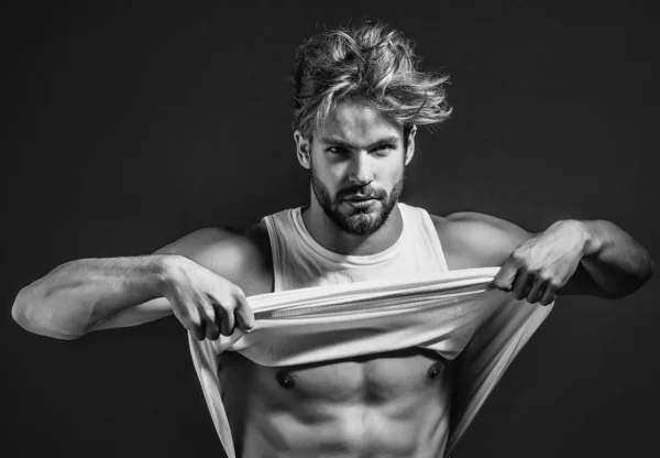 Bello muscoloso uomo sexy in giubbotto bianco ha nudo busto muscolare e petto su sfondo grigio. Spogliati. — Foto Stock