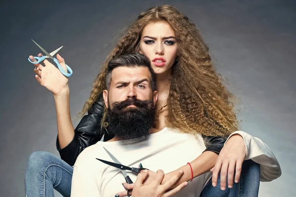 Couple of long-haired young woman holding scissors. Bearded man with moustache in barber shop. Sexy barbershop concept. Barber with beard. — Stock Photo, Image