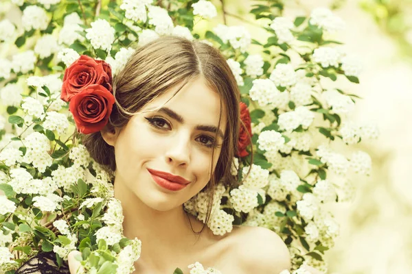 Mujer joven en flor de primavera. Chica bonita con maquillaje de moda y labios rojos. Estilo hispano. Flor de primavera sobre fondo natural. — Foto de Stock