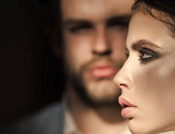 Flicka med makeup, ögonskuggor, rouge, foundation. Kvinna ansikte profil med suddig man på bakgrunden. Ett par modemodeller. — Stockfoto