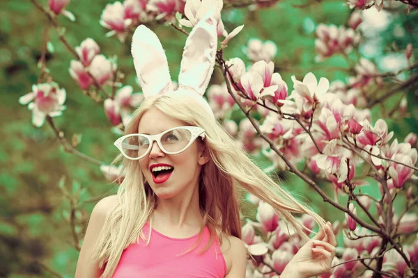 İlkbaharda, çiçek açan manolya çiçekli komik çılgın genç kadın. Mutlu Paskalyalar. Tavşan kulaklı seksi kadın. Bahar, doğa ve çevre. — Stok fotoğraf