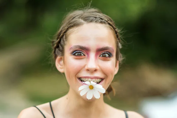 Mulher jovem feliz fummy com flor margarida na boca. A Primavera da Beleza. Na Primavera. Juventude, floração flor. — Fotografia de Stock