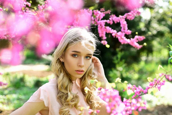 Mladá žena má ráda květiny na zahradě. Dívka kráčí v parku na slunném jarním dni. — Stock fotografie