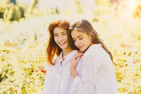 Mujeres amigas niñas posando en el fondo de la naturaleza verde. Concepto de vida. — Foto de Stock