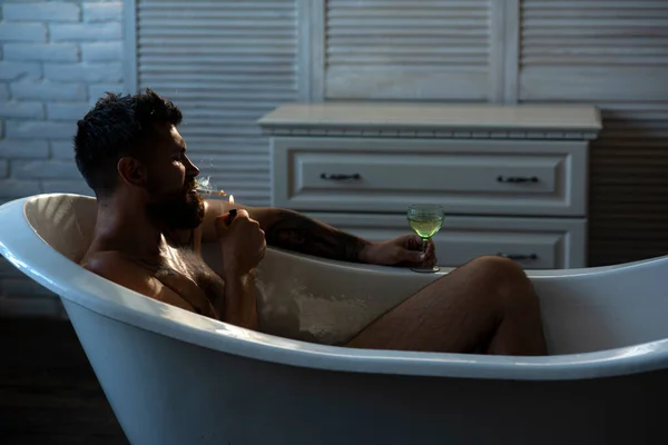 Sakallı adam banyoda sigara ve içki içiyor. Depresyon erkeği. Olumsuz duygular. — Stok fotoğraf