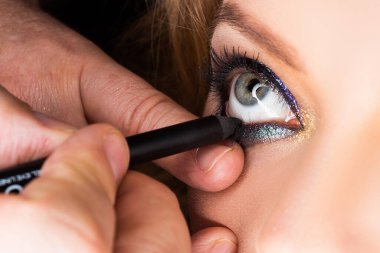 Göz makyajı yap. Göze yakın çekim. Göz farı, göz farı, makyaj..