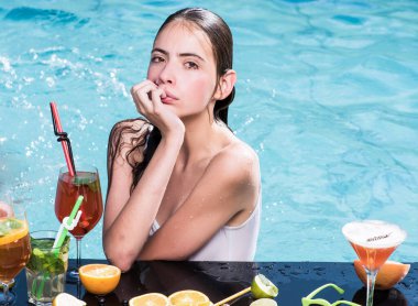 Miami 'de at kuyruklu genç bir kadın. Islak kız havuzda kokteyl içer..