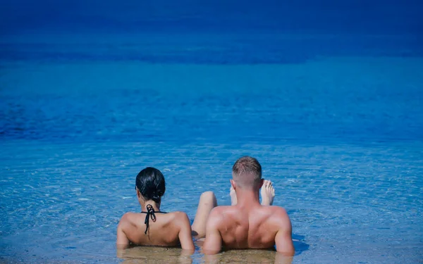 Preciosa pareja en la playa tropical en el agua. Verano relax. — Foto de Stock