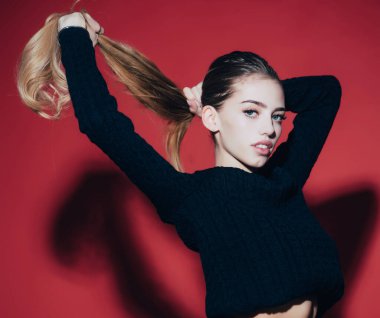 Kırmızı arka planda uzun saçlı seksi bir manken..