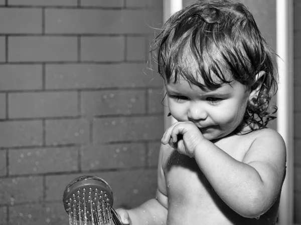 Schattig glimlachen grappige jongen kind met nat haar nemen douche in bad met water binnen. — Stockfoto