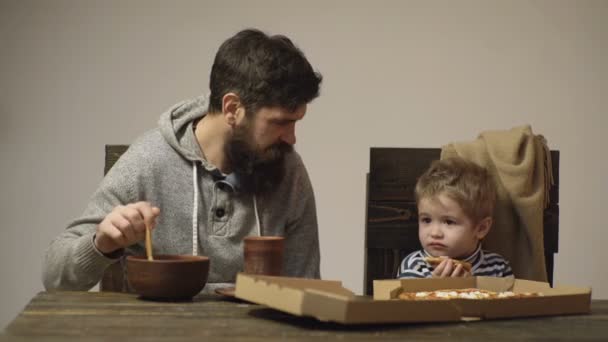 Papá y el niño comiendo pizza. Pizzería. Cocina italiana. Feliz infancia. Comida chatarra rápida cena almuerzo. — Vídeos de Stock