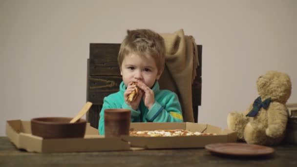 Пиццерия. Мальчик ест пиццу. Фастфуд. Дети нездорового питания. Итальянская кухня. — стоковое видео