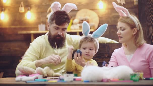 Easter family with rabbit ears. Bunny with colour eggs. Feeding rabbits. Holiday concept. — Stock Video