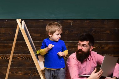 Öğretmen tahtada öğrencinin çalışmalarını kontrol ediyor. Çocuk eğitimi konsepti.