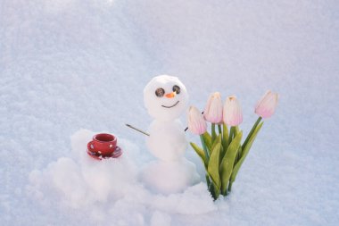 Merhaba ilkbahar, güle güle kış. Kahve fincanlı kardan adam. Çiçekli kardan adam.