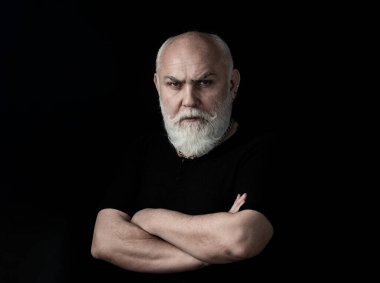 Siyahta izole edilmiş kameraya bakan ciddi kıdemli adam. Yakın plan stüdyo resmi, stüdyoda kameraya bakan gri saçlı yaşlı bir adam..