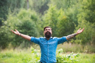 Dışarıda bir adam yağıyor. Olumlu düşün. Fırtınalı hava. Yağmurda meditasyon. Rahatlama kavramı.