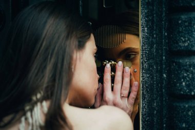 Kadın dahili iletişim düğmesi. Bina girişindeki bayan kapı zili. Genç elbiseli kadın kapı klavyesine kod giriyor..