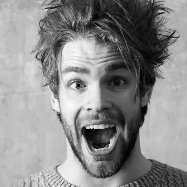Funny excited man with open Screaming nouth, close up. Young sexy man or handsome caucasian guy portrait