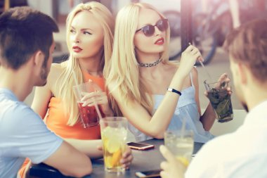 Arkadaşlar kahve dükkanının terasında konuşuyor ve gülüyor..