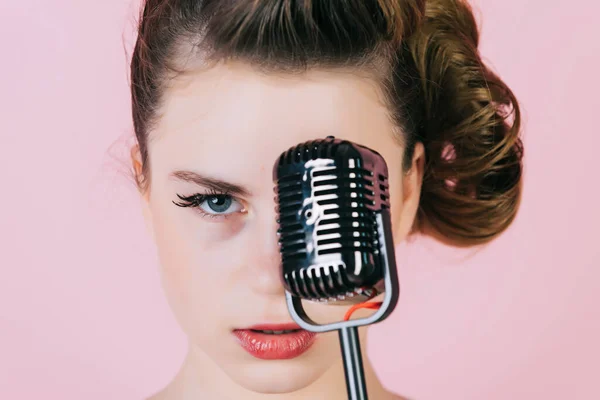 Girl in glasses sing in microphone. Beauty and vintage fashion. Music, look and retro style. Pinup young girl with retro microphone. Girl sing. Karaoke singer, closeup face